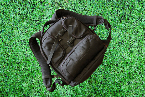 Чорний спортивний рюкзак на зеленій траві
 - Фото, зображення