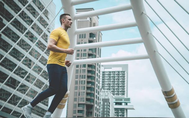Sport fitness man is jogging in modern city morning - Foto, imagen