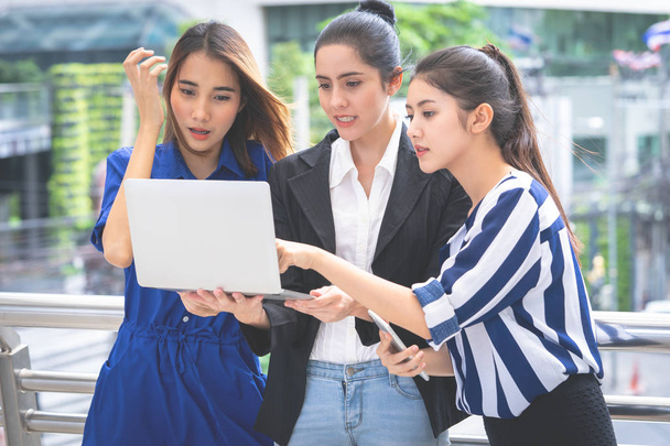 Три бізнес-леді тримає ноутбук для команди онлайн-маркетингу
 - Фото, зображення