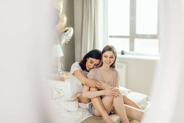 young good looking girls in positive mood spending time on bed - Фото, зображення
