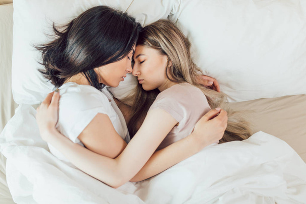 awesome young girls hugging, sleeping in the bedroom - Fotografie, Obrázek