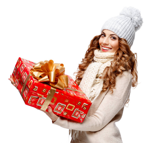 Beautiful young woman in knitted woolen sweater smiling holding gift boxes - Fotografie, Obrázek