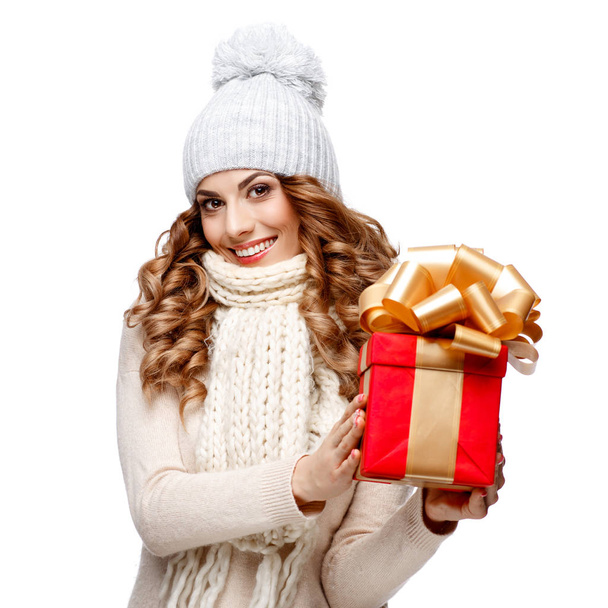 Beautiful young woman in knitted woolen sweater smiling holding gift boxes - Zdjęcie, obraz