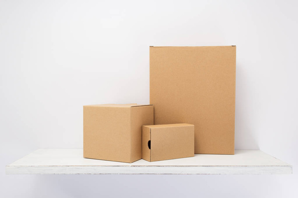 cardboard box on wooden shelf  - Φωτογραφία, εικόνα