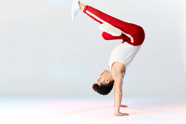 Asian Bboy standing in freeze stunt upside down balancing in air with legs - Zdjęcie, obraz
