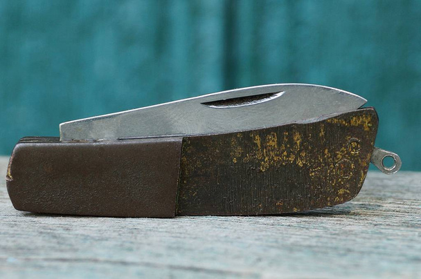 μικρό παλιό Αναδιπλούμενο μαχαίρι με καφέ μπρούτζινο χερούλι - Φωτογραφία, εικόνα