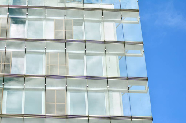 Nuevo edificio de oficinas en el centro de negocios. Pared de acero y vidrio con cielo azul.  - Foto, imagen