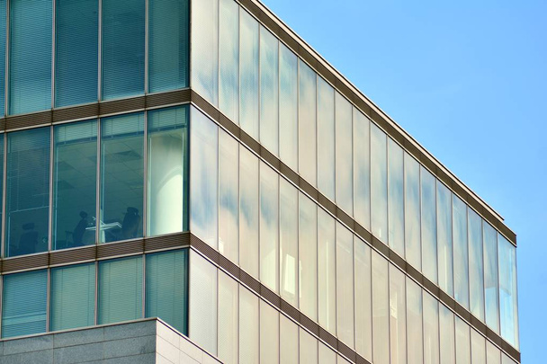Νέο κτίριο γραφείων στο επιχειρηματικό κέντρο. Τοίχος από ατσάλι και γυαλί με μπλε ουρανό.  - Φωτογραφία, εικόνα