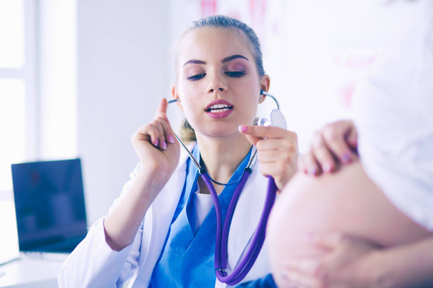 Jovem médica examinando mulher grávida na clínica. - Foto, Imagem