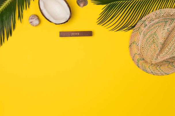 Creative Flat lay fashion style with palm leaves, coconut and panama hat on yellow color background - Foto, immagini