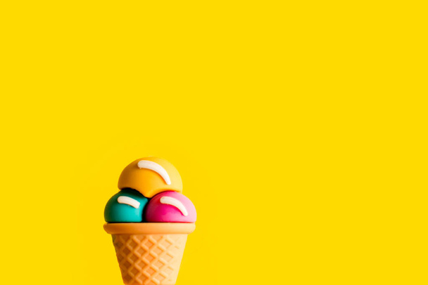 Ice cream cone different flavors on a yellow background. plastic toy macro - Φωτογραφία, εικόνα