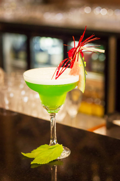 grüner alkoholischer Cocktail mit Minze im Margarita-Glas auf der Theke - Foto, Bild