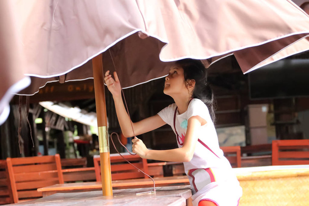 Ασιατικό κορίτσι αυξήσει μια ομπρέλα, φοιτητές ή παιδιά που εργάζονται σε th - Φωτογραφία, εικόνα