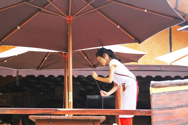 Ασιατικό κορίτσι αυξήσει μια ομπρέλα, φοιτητές ή παιδιά που εργάζονται σε th - Φωτογραφία, εικόνα