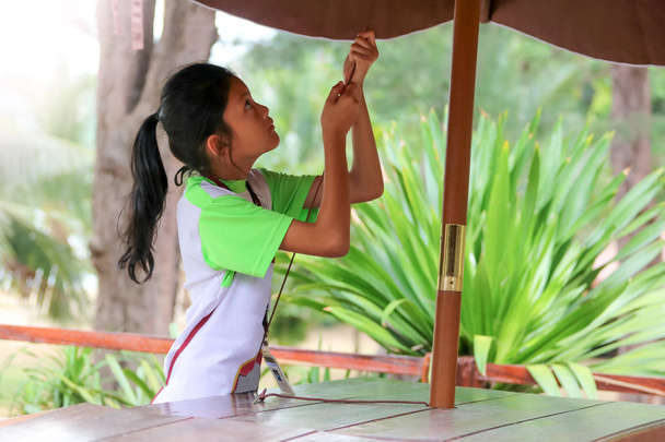 Asiática chica levantar un paraguas, Estudiantes o niños trabajando en th
 - Foto, imagen