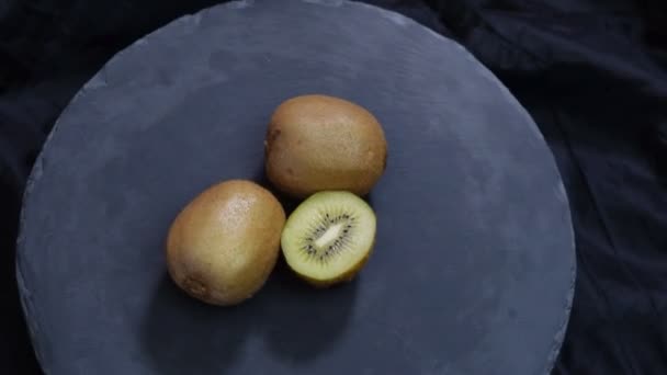 Fruta kiwi rotativa sobre fundo preto. Vista superior
. - Filmagem, Vídeo