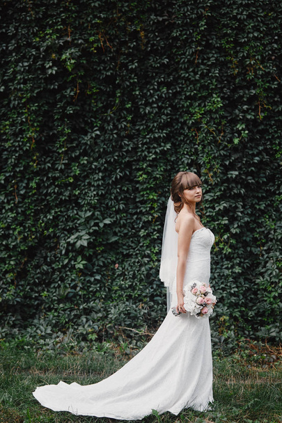 Невеста в модном свадебном платье на естественном фоне. В день свадьбы. Красивый портрет невесты
. - Фото, изображение