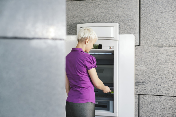 jeune femme retirer de l'argent avec carte au guichet automatique
 - Photo, image