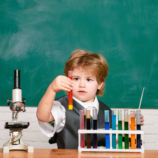 They carried out a new experiment in chemistry. Kid is learning in class on background of blackboard. Knowledge day. schoolboy. September 1. - Foto, imagen