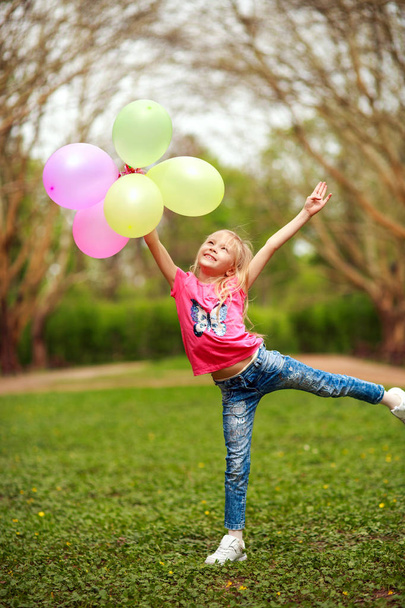 Gelukkig meisje met ballonnen springen in stadspark vieren zomer - Foto, afbeelding