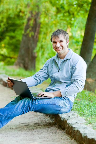 Счастливый человек с ноутбуком на открытом воздухе
 - Фото, изображение