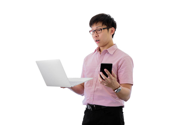 Asiático jovem empresário tem de pé e segurando telefone e lapt
 - Foto, Imagem