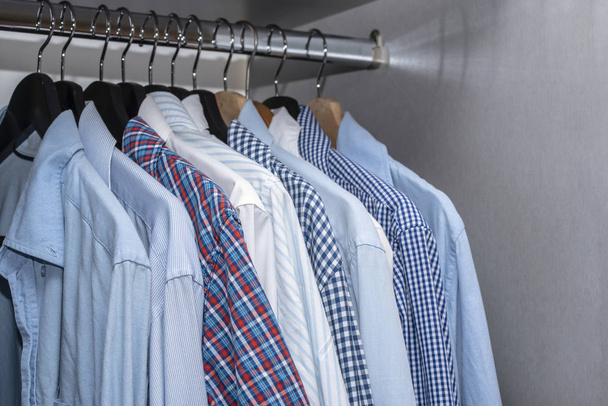 Άνδρες πουκάμισα κρέμονται στο ντουλάπι στο Living Apartment εσωτερικό εσωτερικών χώρων - Φωτογραφία, εικόνα