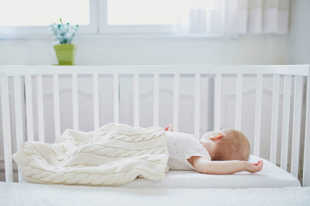 Baby sleeping in co-sleeper crib attached to parents' bed - Foto, imagen