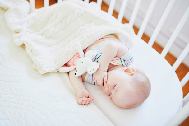 Vauva nukkuu yhteistyössä nukkuva pinnasänky kiinnitetty vanhempien sänkyyn
 - Valokuva, kuva