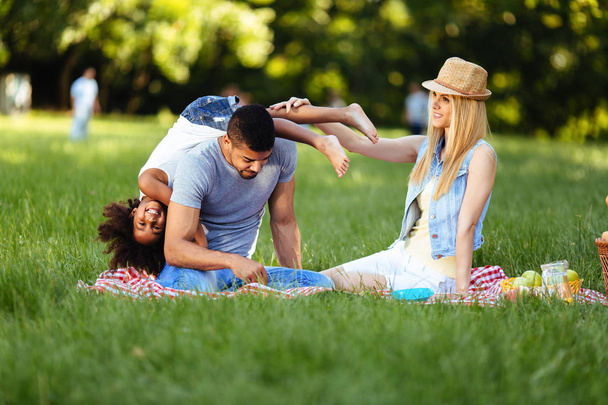 Picture of lovely couple with their daughter having picnic in nature - Foto, immagini