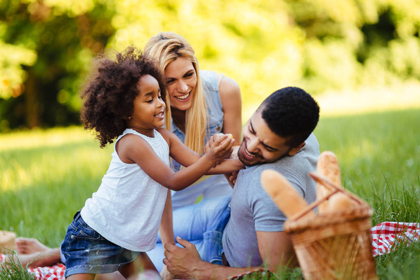Familia feliz divirtiéndose juntos en el picnic
 - Foto, Imagen