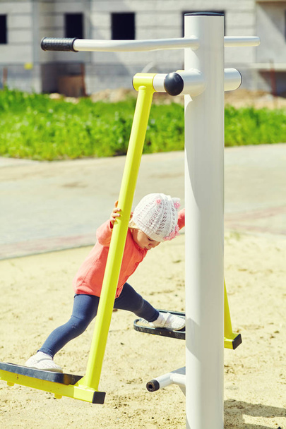Active little girl on playground. child playing outdoors in the summer - Foto, afbeelding