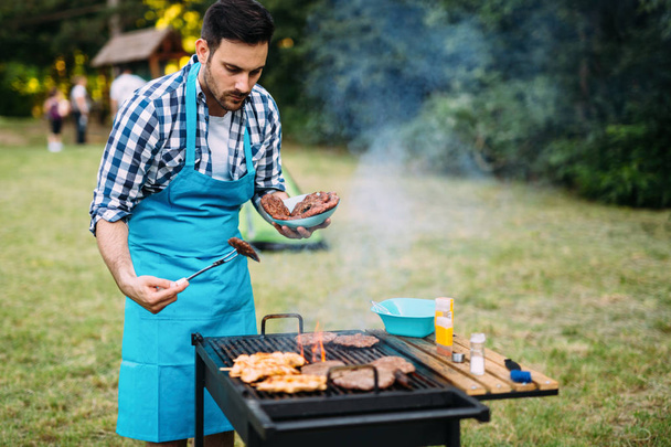 Happy male grilling bbq meat outdoor in nature - Fotografie, Obrázek