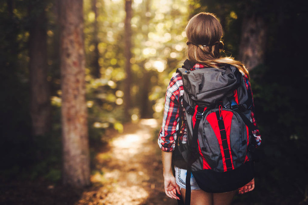Portrait of pretty backpacker woman hiking in forest - Фото, изображение