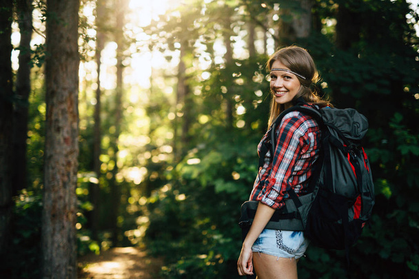 Portrait of pretty backpacker woman hiking in forest - Fotoğraf, Görsel