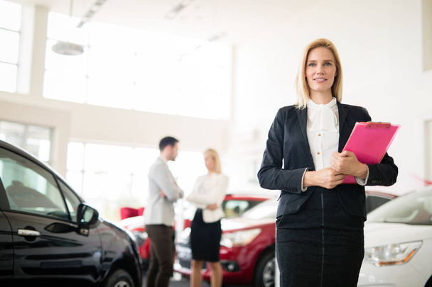 Professional gorgeous saleswoman at car dealership in formal wear. Super consultant or manager - Φωτογραφία, εικόνα