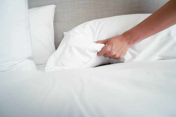Hembra mano establecer sábana blanca en la habitación del hotel
 - Foto, imagen