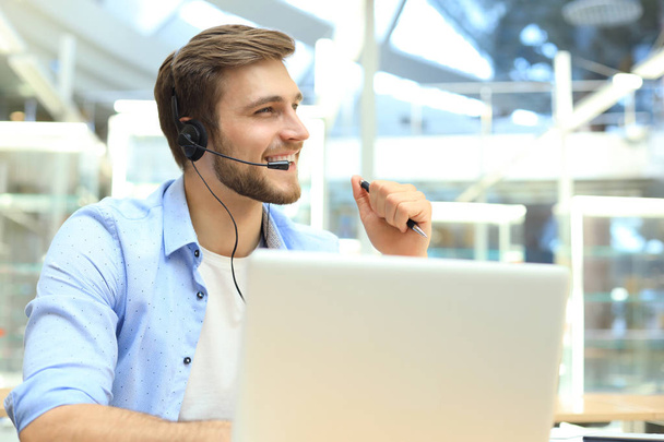 Happy young male customer support executive working in office. - Фото, зображення
