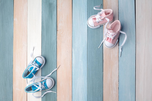 Cute tiny baby shoes on a wooden background with space for text - Foto, Imagen