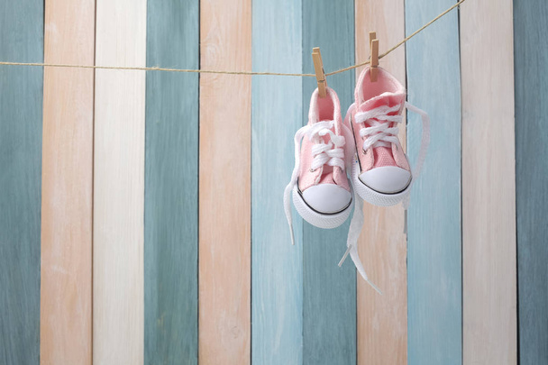 Cute tiny baby shoes on a wooden background with space for text - 写真・画像