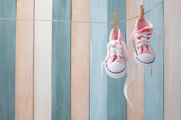 Cute tiny baby shoes on a wooden background with space for text - Foto, Imagen