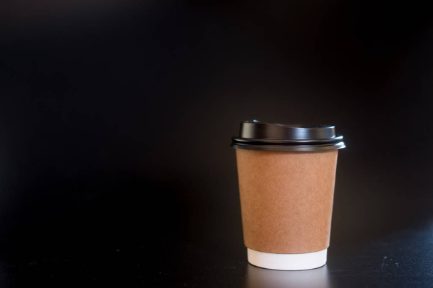 Χάρτινο κύπελλο για καφέ σε μαύρο φόντο - Φωτογραφία, εικόνα