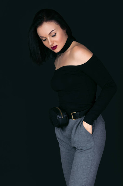 woman in black sweater with handbag posing in studio - Fotografie, Obrázek