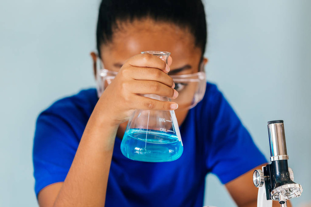 Young African American kid doing chemistry experiment - Foto, afbeelding