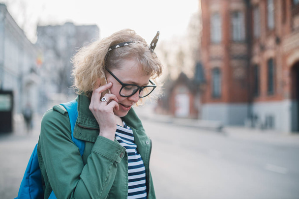 Νεαρή γυναίκα που μιλά στο τηλέφωνο στο παρασκήνιο της Ευρώπης - Φωτογραφία, εικόνα