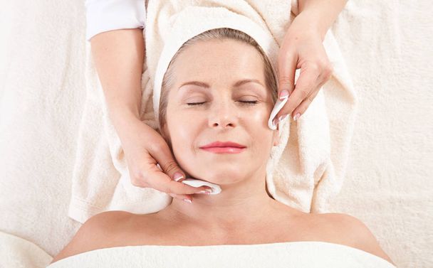 masaje facial en macro spa. Mujer atractiva con ojos cerrados que cuida la piel. Masaje cara enfoque selectivo
. - Foto, imagen
