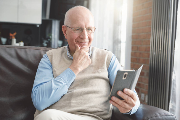 Улыбающийся пожилой человек с помощью смартфона
 - Фото, изображение