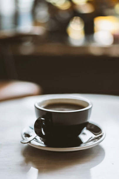 hot coffee cup in the coffee shop with soft-focus and over light - Fotó, kép