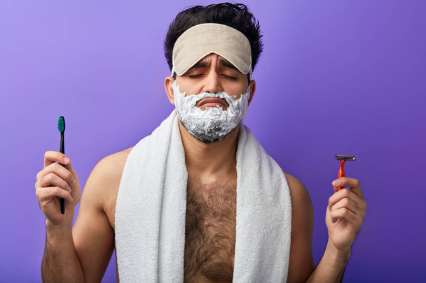 Sleepy attractive handsome man with closed eyes,shaving foam on his face - 写真・画像