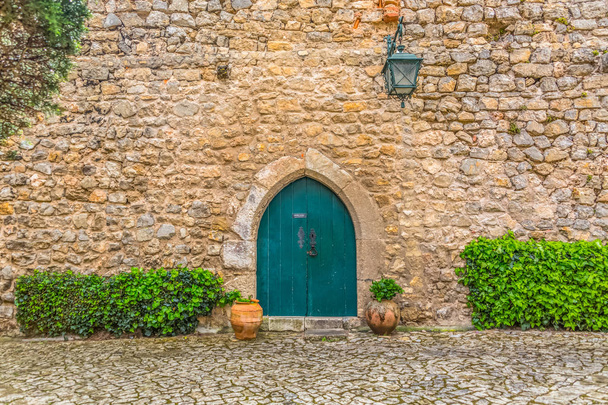 Vista de la puerta medieval del castillo romano de Luso de Obidos, con maceta de cerámica con plantas, en Portugal
 - Foto, Imagen